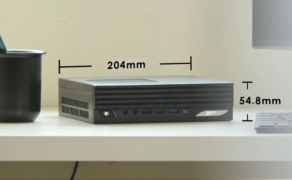Komputer MSI Pro DP21 14M-889EU Komputer typu mini PC leżący poziomo na jasnym biurku z naniesionymi liniami wymiarowymi wskazującymi szerokość 204 mm oraz wysokość 54.8 mm, przeznaczenie, wielkość, obudowa