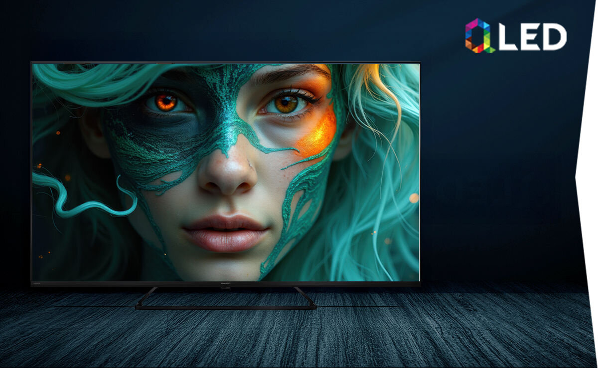Telewizor SHARP 65HP6765E QLED Quantum Dot szeroka paleta barw naturalne kolory, telewizor stojący na podłodze w ciemnym pomieszczeniu