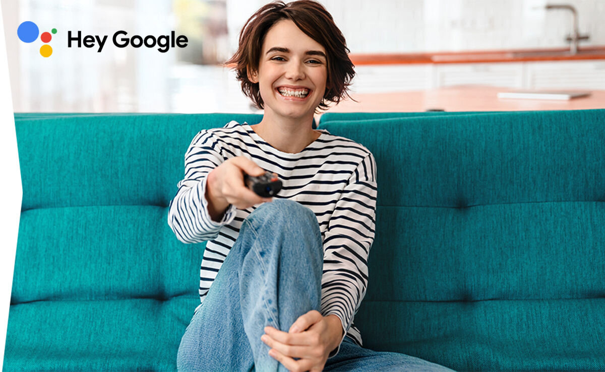 Telewizor SHARP 65HP6765E Asystent Google sterowanie głosem, osoba siedząca na kanapie z pilotem w ręku