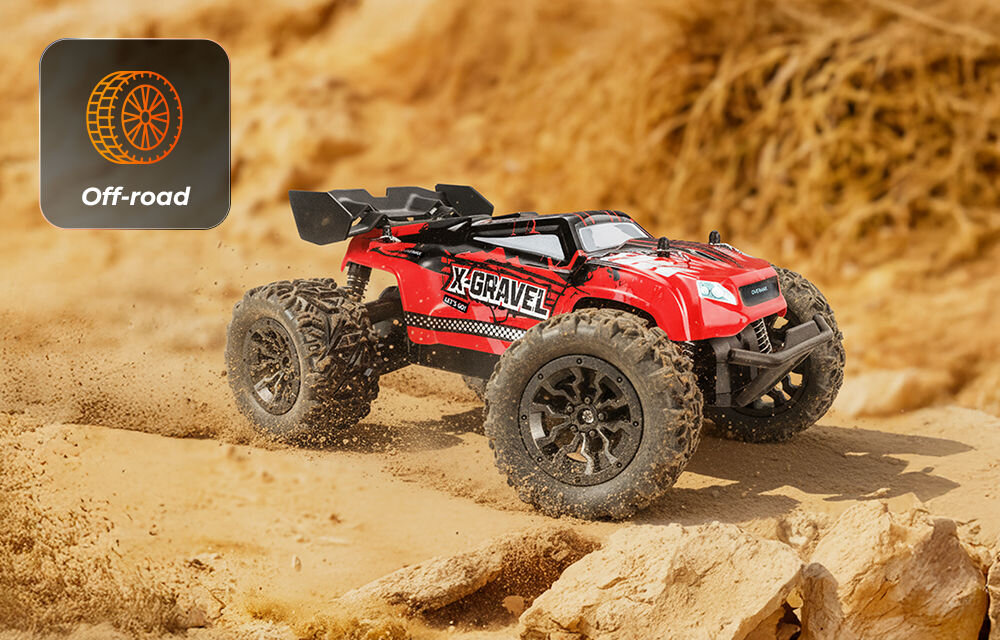 Samochód zdalnie sterowany OVERMAX X-Gravel Czerwony samochód zdalnie sterowany w ruchu na piaszczystym, kamienistym terenie (off-road). Koła wzniecają kurz. Ikona w lewym górnym rogu potwierdza przeznaczenie terenowe (Off-road).
