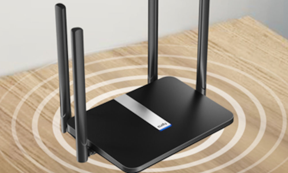 Czarny router z czterema antenami, umieszczony na drewnianej powierzchni. Na urządzeniu widoczne jest logo \'cudy\'.