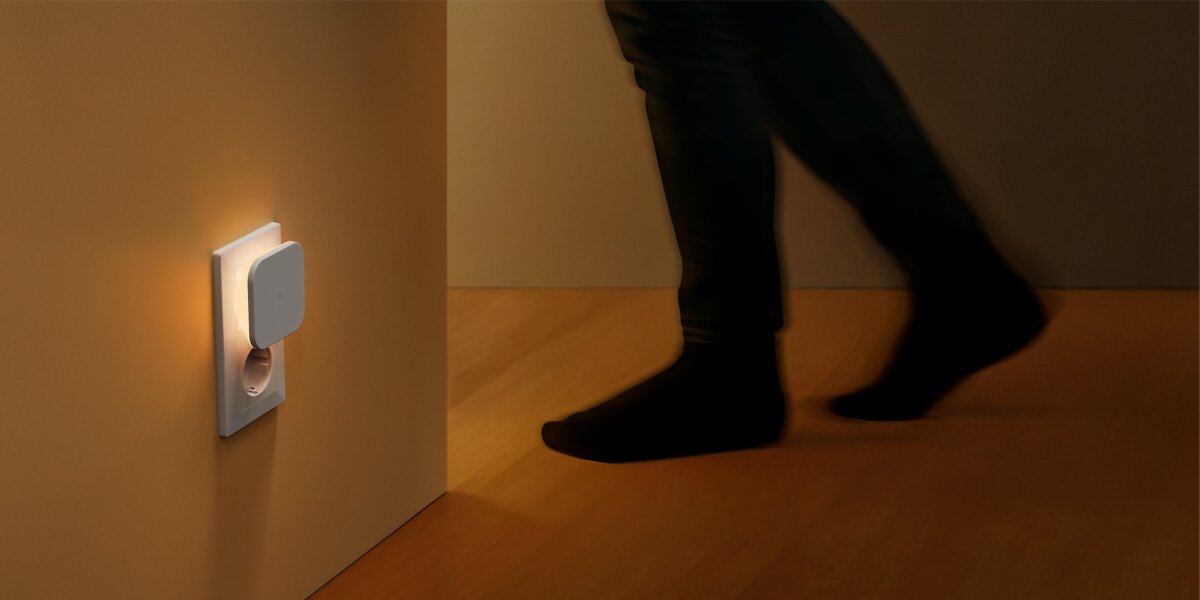 Lampka nocna HAMA Cozy z czujnikiem ruchu i zmierzchu Inteligentna lampka nocna do kontaktu świecąca ciepłym światłem w ciemnym przedpokoju, aktywowana przez czujnik ruchu podczas przechodzenia osoby.