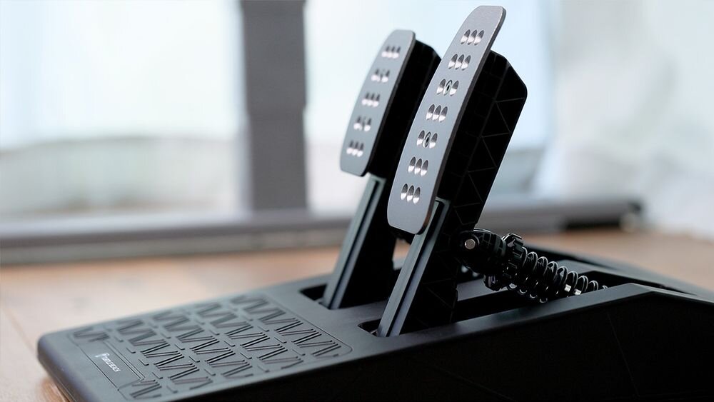 Kierownica Turtle Beach Velocity OneRace KD3 Zbliżenie na moduł pedałów wyścigowych z metalowymi nakładkami, ustawiony na podłodze przy biurku miękka tekstura materiał klasy premium aluminiowe pedały