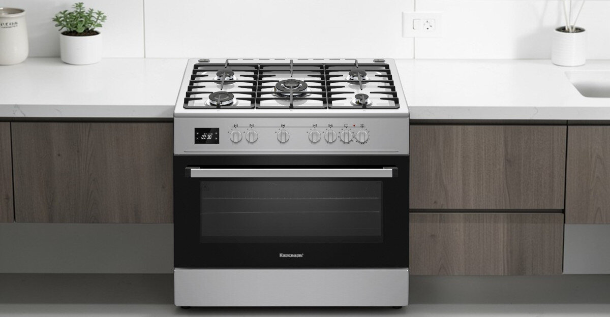 Na obrazie widoczna jest kuchnia wolnostojąca z czterema palnikami gazowymi i piekarnikiem. Na froncie piekarnika znajduje się logo \'RAVANSON\'.