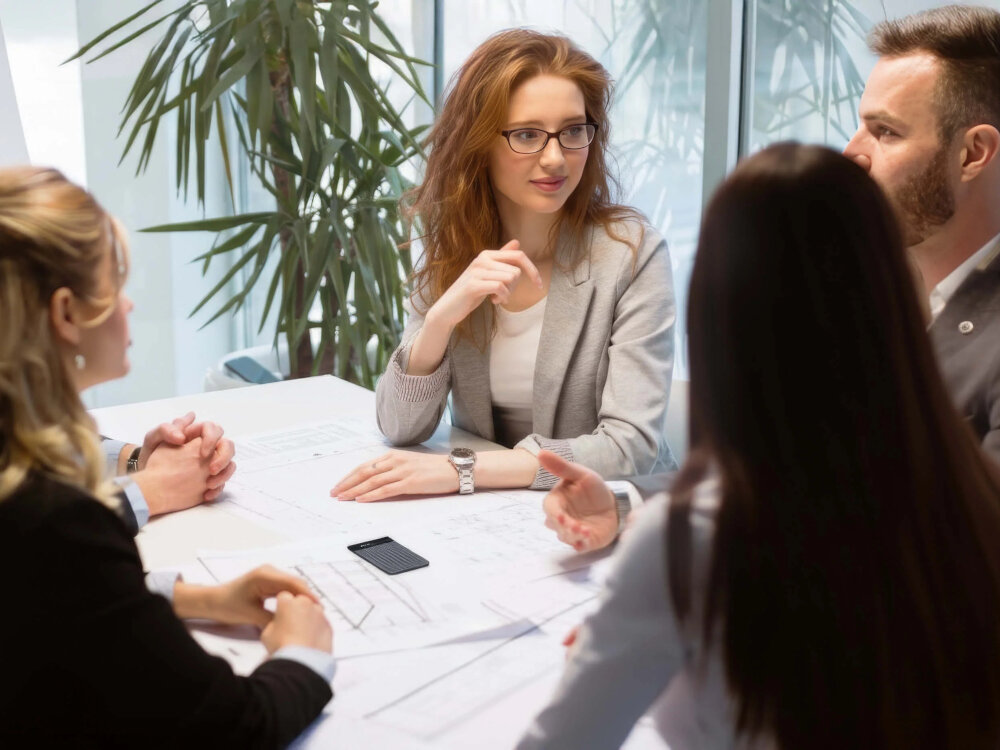PLAUD Note PRO mikrofony MEMS redukcja szumów dźwięk wyraźny, osoby siedzące przy stole, dyktafon leżący na stole