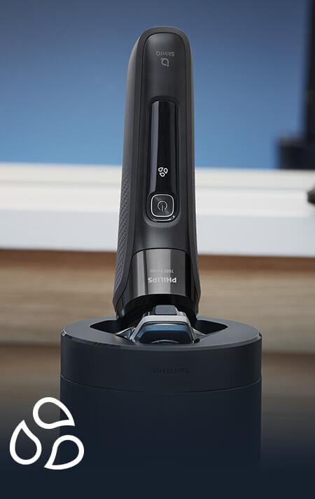 Na obrazie widoczna jest golarka z logo Philips, umieszczona w stacji dokującej. W dolnym rogu znajduje się symbol trzech kropli.