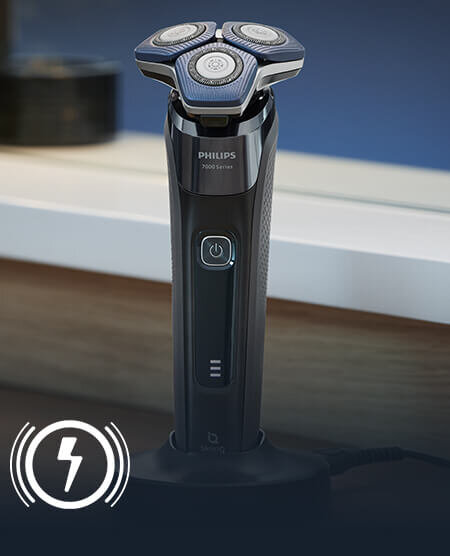 Golarka elektryczna z trzema okrągłymi głowicami, stojąca na podstawce. Na urządzeniu widoczne jest logo \'PHILIPS\' oraz napis \'7000 Series\'.