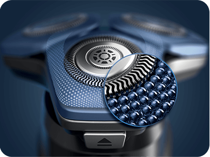 Zbliżenie na głowicę golarki z trzema okrągłymi ostrzami, z powiększeniem pokazującym teksturę powierzchni tnącej. Golarka ma niebieski kolor z metalicznymi elementami.