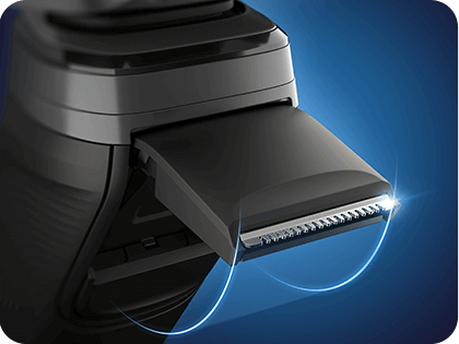 Zbliżenie na wysuwany trymer golarki z widocznymi ostrzami, otoczony niebieską poświatą.