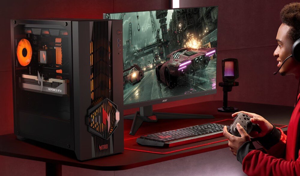 Na biurku znajduje się komputer stacjonarny z podświetleniem RGB oraz monitor wyświetlający grę wyścigową. Obok monitora leży klawiatura i mysz, a osoba trzyma kontroler do gier.