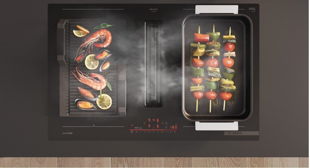 PŁYTA BOSCH PXL811H26E Na zdjęciu widać płytę indukcyjną Bosch zintegrowaną z wyciągiem środkowym, na której po lewej stronie grillowane są owoce morza, a po prawej kolorowe warzywne szaszłyki. Para z potraw jest odprowadzana bezpośrednio do centralnego wlotu, co podkreśla skuteczność wbudowanego systemu odciągu czujnik smażenia PerfectFry Plus ulubione potrawy aplikacja przepisy Bosch Alexa temperatura automatyczne ustawienie inteligentna technologia perfekcyjne smażenie