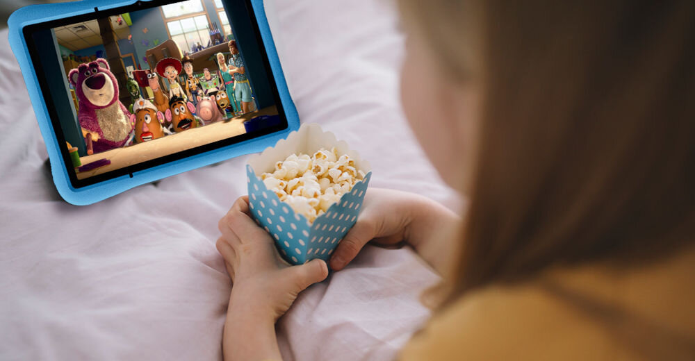 Tablet OSCAL Pad 60 Kids 10.1 cali 4/128 GB Wi-Fi Niebieski prezentacja urządzenia podczas oglądania bajki tablet na łóżku dziewczyna oglądająca film z popcornem w rękach ekran IPS cala rozdzielczość 800 x 1280 px proporcje 16:10 jasność do 300 nitów szeroki kąt widzenia komfort oglądanie bajek granie w gry edukacyjne