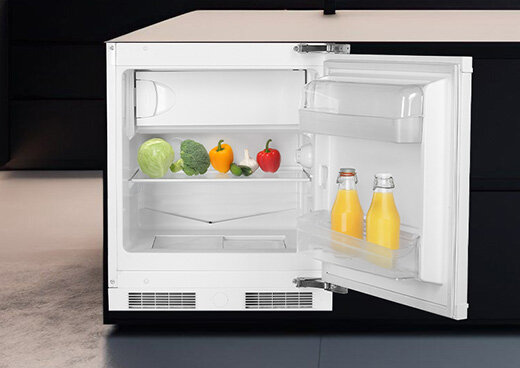 Otwarta lodówka w zabudowie kuchennej.