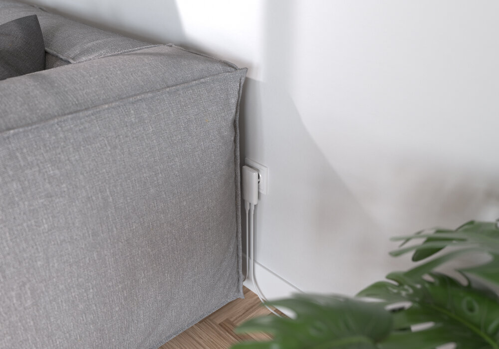 ALLITY ATC-02-65WAC Allity płaskiej konstrukcji portom ładowania umieszczonym od spodu - ładowarka podłączona do gniazdka za kanapą, widoczne dwa kable wychodzące w stronę mebli