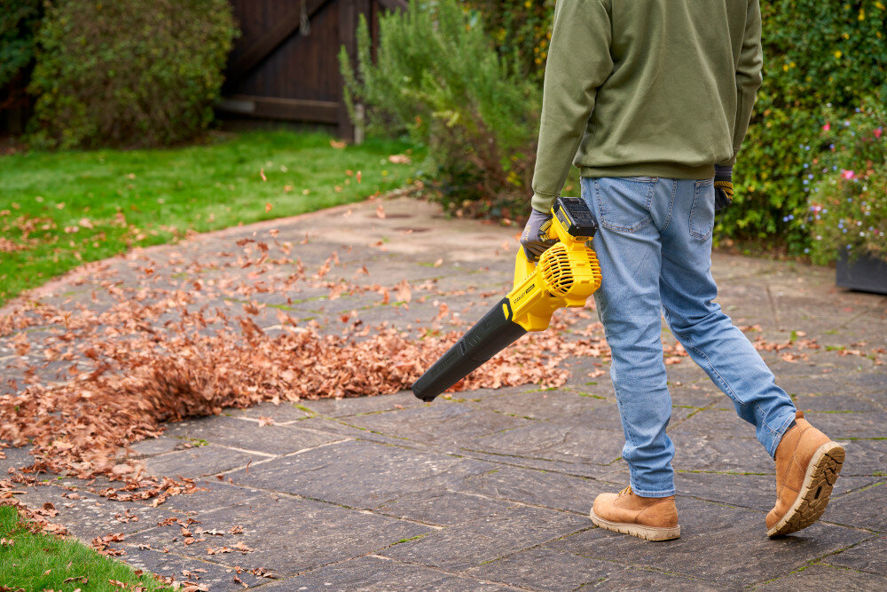 Dmuchawa do liści akumulatorowa STANLEY 20V SFMCBL714B-XJ SOLO ogród osoba zdmuchuje liście z chodnika zasięg działania do 3 metrów można usuwać zanieczyszczenia spod ścian, krawędzi czy zaparkowanych pojazdów praca przebiega płynniej i wymaga mniejszej liczby ruchów ograniczając zmęczenie ramion i pleców