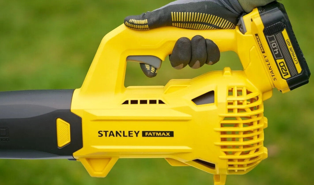 Dmuchawa do liści akumulatorowa STANLEY 20V SFMCBL714B-XJ SOLO zbliżenie na uchwyt osoba trzyma dmuchawę w dłoni teksturowany uchwyt ogranicza ślizganie się dłoni lekki wentylator osiowy waga około 1,5 kg bez akumulatora stabilny chwyt precyzyjniej kierować strumień powietrza