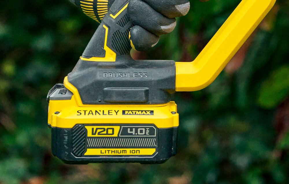 Piła akumulatorowa STANLEY SFMCPS720B-XJ SOLO rozmazane tło zbliżenie na akumulator osoba trzyma piłę w dłoni akumulator litowo-jonowy z serii STANLEY Fatmax V20 brakiem efektu pamięci niskie samorozładowanie pełna swoboda ruchu wspólny system zasilania STANLEY Fatmax V20 jeden akumulator w wielu narzędziach