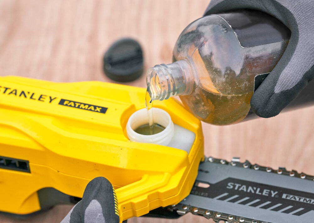 Piła akumulatorowa STANLEY SFMCPS720B-XJ SOLO drewniany blat piła na blacie osoba uzupełnia olej w pile automatyczny hamulec łańcucha zatrzymuje go w czasie krótszym niż jedna sekunda ogranicza skutki niekontrolowanego ruchu zwiększa poczucie kontroli bezpieczeństwo prace ogrodowe w spokojnym tempie zbiornik na olej o pojemności 150 ml długotrwałe smarowanie łańcucha bez konieczności częstego uzupełniania