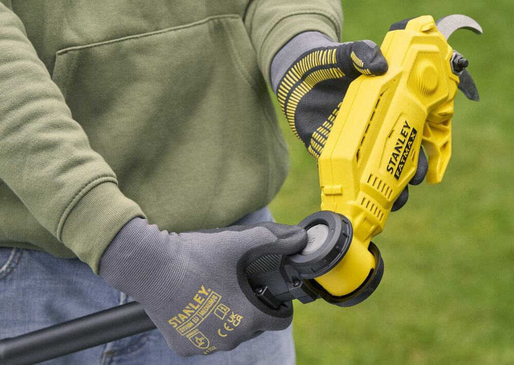 Sekator do gałęzi akumulatorowy STANLEY FatMax SFMCPP632B-XJ rozmyte zielone tło osoba trzyma sekator w dłoni zbliżenie na głowicę osoba trzyma przycisk do regulacji w dłoni regulowana głowica z pięcioma ustawieniami kąta można precyzyjnie ciąć gałęzie w trudno dostępnych miejscach dopasować pozycję ostrza do kierunku wzrostu gałęzi kontrola i dokładność cięcia