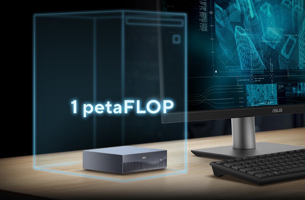 Komputer ASUS Ascent GX10 Ustawiony na drewnianym biurku srebrny komputer typu mini PC wewnątrz świecącego niebieskiego prostopadłościanu, z którego górnej krawędzi odchodzi świecąca niebieska linia do lewego boku czarnego monitora, a z przodu widnieje świecący biały napis '1 petaFLOP'