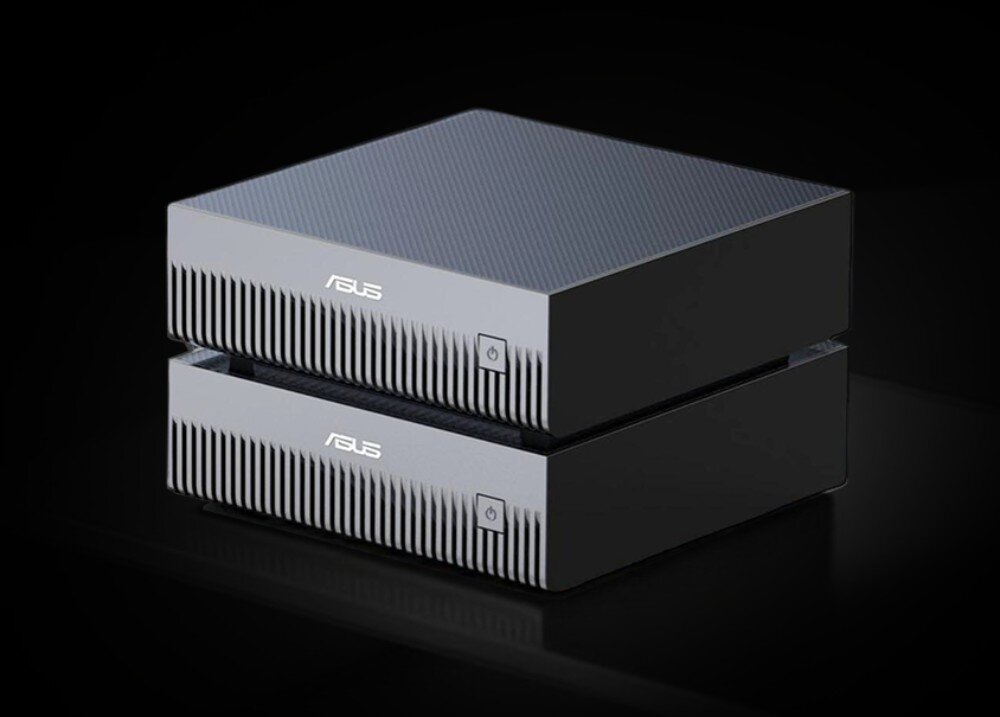 Komputer ASUS Ascent GX10 Dwa identyczne, srebrne komputery typu mini PC, jeden postawiony na drugim, na gładkiej czarnej powierzchni z ciemnym tłem