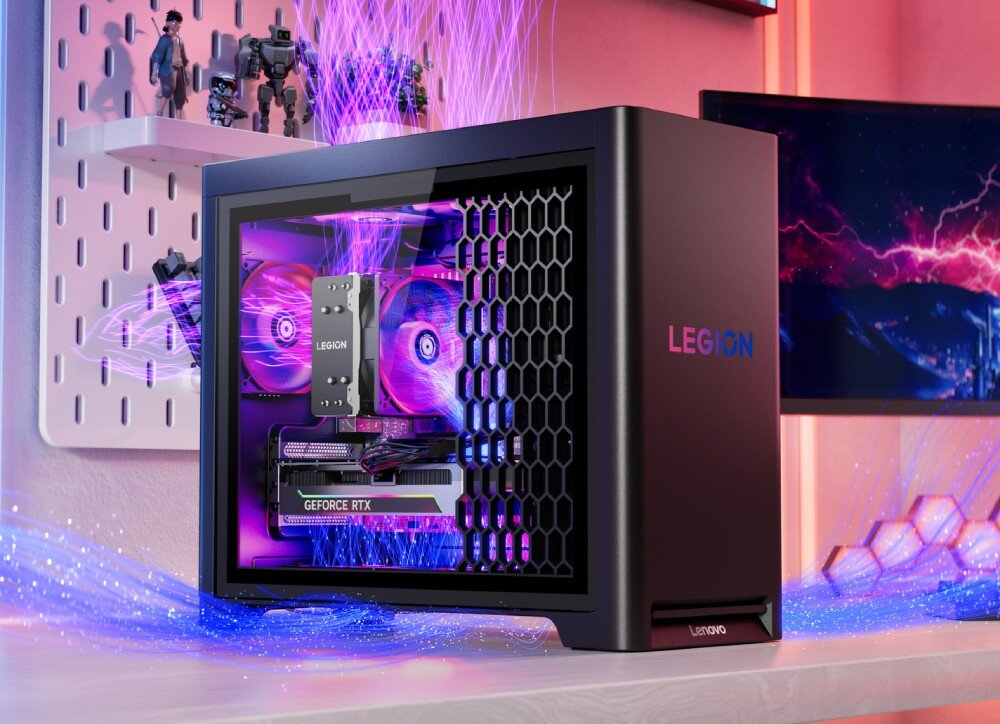 Komputer LENOVO Legion T5 30AGB10 Komputer z przezroczystym bokiem i podświetlonymi wentylatorami w kolorze fioletowym ustawiony na biurku obok monitora