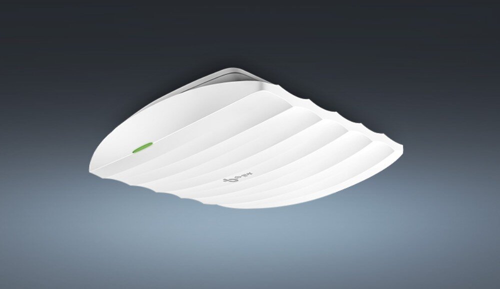 Punkt dostępu TP-LINK EAP110 Access Point Widok z dołu zamontowanego na suficie punktu dostępowego o białej, falistej obudowie z widoczną zieloną diodą, opis