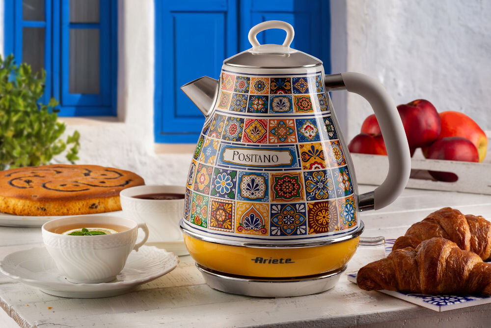 Czajnik ARIETE Positano 28690 do każdej kuchni czajnik stoi na kamiennym blacie żółto niebieska obudowa mozaika dwie filiżanki napoje wewnątrz