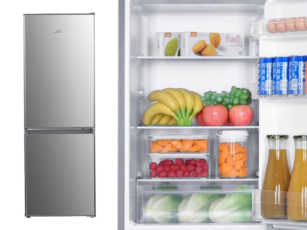 Lodówka ETA ETA385690010C Lodówka wolnostojąca w stalowym kolorze z dolnym zamrażalnikiem, obok zbliżenie na jej wnętrze wypełnione świeżymi owocami, warzywami i napojami pojemność 173 l chłodziarka 121 l zamrażarka 52 l dla singli par rodzin zamrażanie 2,6 kg 7 h podtrzymanie