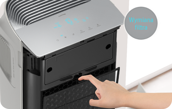 Zbliżenie na wymianę filtra w oczyszczaczu powietrza, osoba obsługująca filtr.