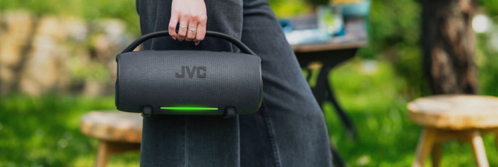 Głośnik mobilny JVC XS-E524B 50 W TWS stereo wyraziste basy klarowne wysokie tony, osoba trzymająca głośnik za uchwyt