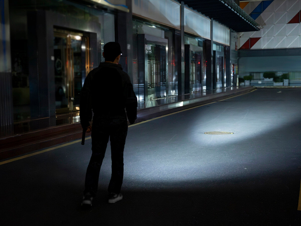 Latarka OLIGHT Warrior Ultra OL692425, moc, zasięg, taktyczna, solidność, Patrol nocny z latarką przed budynkiem