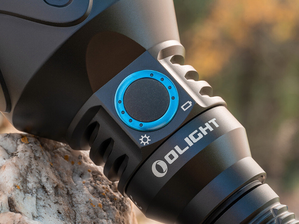 Latarka OLIGHT Javelot Turbo 2 OL003991 Czarny, siła, zasięg, 1800 lumenów, 1500m, Zbliżenie na przycisk sterujący Javelot Turbo 2, aluminiowa obudowa, pierścień z podświetleniem.