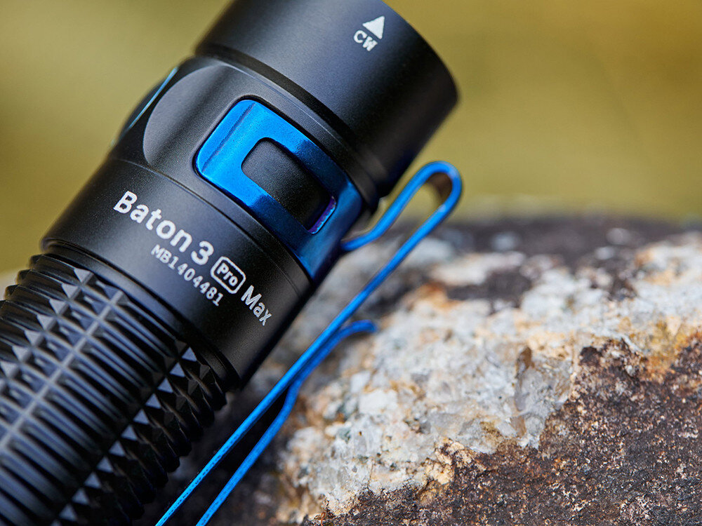 Latarka OLIGHT Baton 3 Pro Max OL000358 Czarny, magnes, zakrętka, stalowy, klips, Olight Baton 3 Pro Max leży na skale, widoczny niebieski stalowy klips, wyraziste napisy.