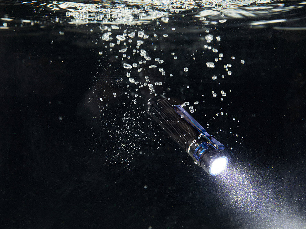 Latarka OLIGHT Baton 3 Pro Max OL000358 Czarny, czujnik, Turbo, bezpieczeństwo, stabilizator, Olight Baton 3 Pro Max świeci pod wodą, widoczne bąbelki, trwałość IPX8, ciemne tło.