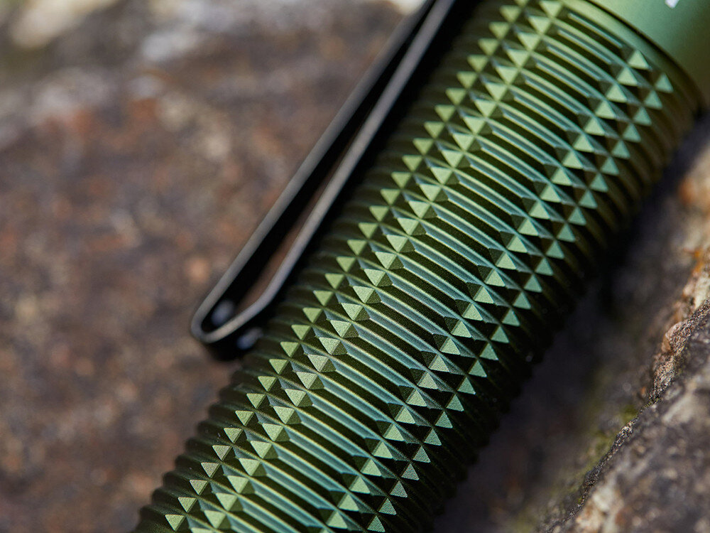 Latarka OLIGHT Baton 3 Pro Max OL001096 Zielony, aluminium, IPX8, chwyt, wytrzymałość, Zbliżenie na teksturowaną powierzchnię korpusu Olight Baton 3 Pro Max, faktura, klips.