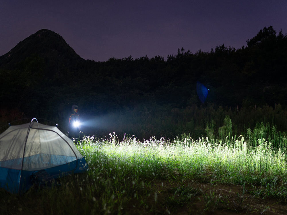 LATARKA OLIGHT BATON 3 PRO CW 1500LM 175M 120 DNI, światło, świecenie, latarka, wsparcie, mężczyzna przemierza teren nocą przy pomocy latarki