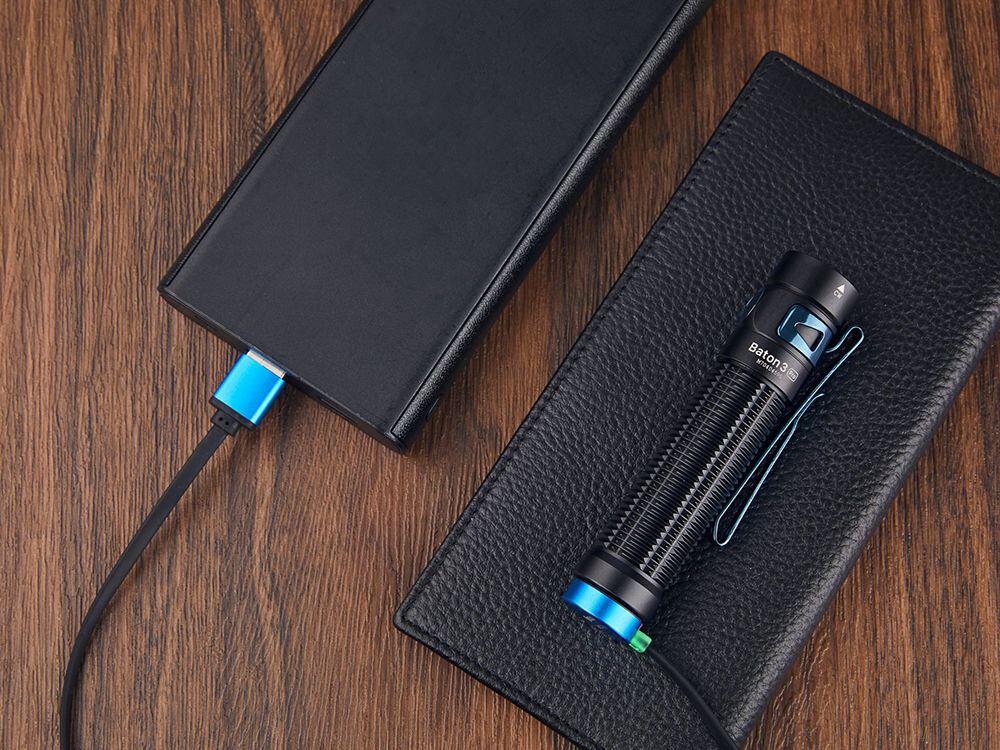 LATARKA OLIGHT BATON 3 PRO CW 1500LM 175M 120 DNI, magnes, pion, przymocowanie, klips, montaż, na blacie leży latarka obok powerbanku