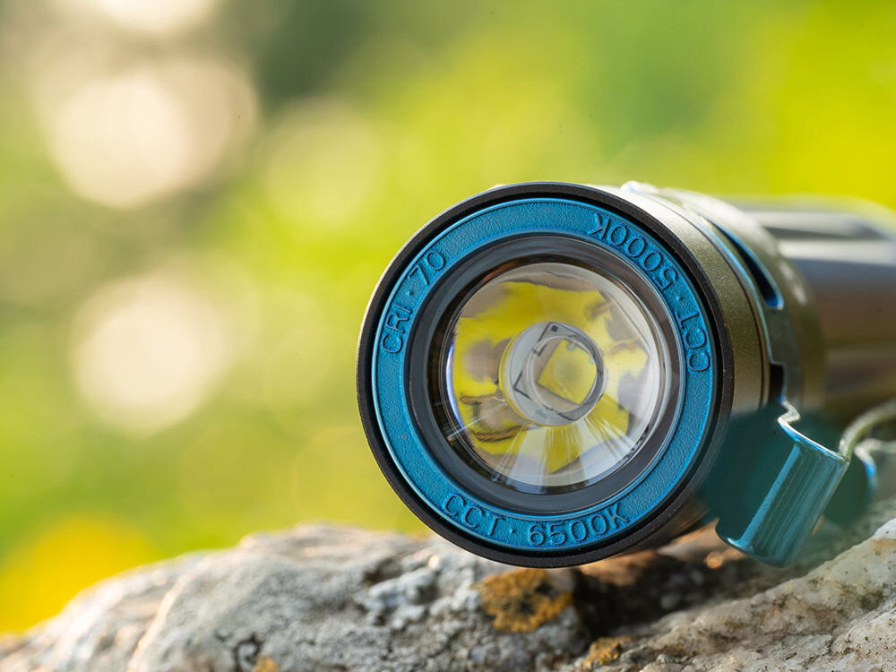 LATARKA OLIGHT BATON 3 PRO CW 1500LM 175M 120 DNI, akumulator, magnetyczny, kabel, ładowanie, zbliżenie na przód latarki która leży na kamieniu