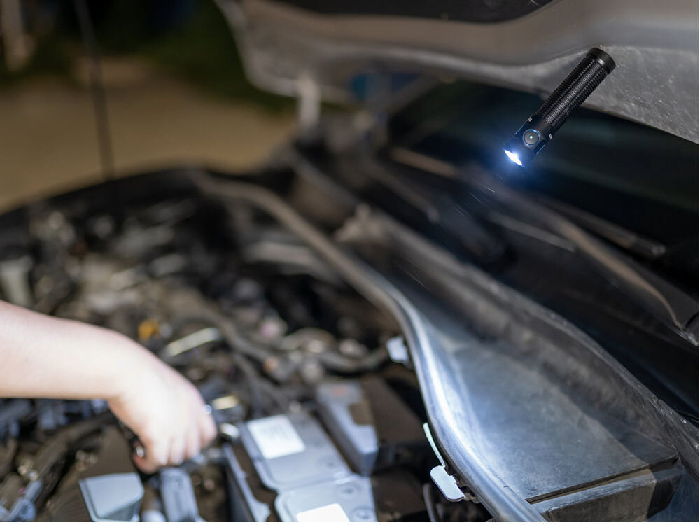 LATARKA OLIGHT BATON 3 PRO CW 1500LM 175M 120 DNI, świecenia, tryby, stroboskopowy, szeroki, moc, latarka przymocowana na magnes do maski auta oświetla silnik auta