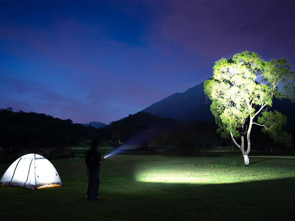 Latarka OLIGHT Arkfeld Class 1 Zielony, 1500 lumenów, chłodzenie, przycisk, regulacja, Latarka oświetla drzewo obok namiotu