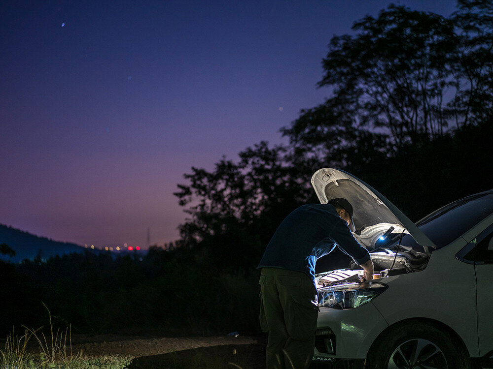 Latarka OLIGHT Arkfeld Ultra UV OL690971 Oliwkowo-szary, elektronika, stabilność, bezpieczeństwo, wydajność, Mężczyzna naprawia auto z latarką nocą