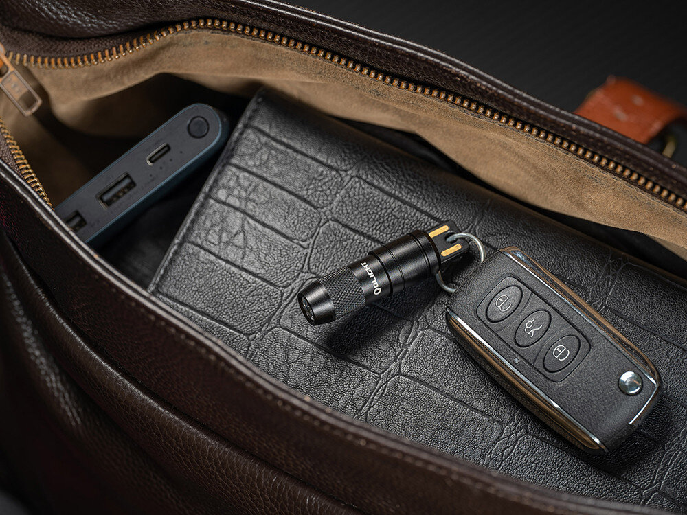 Latarka OLIGHT iMini 2 OL001652 Czarny, ergonomia, klucze, lekkość, minimalistyczny styl, Brelok Olight iMini 2 przypięty do kluczy, leży w otwartej torebce damskiej.