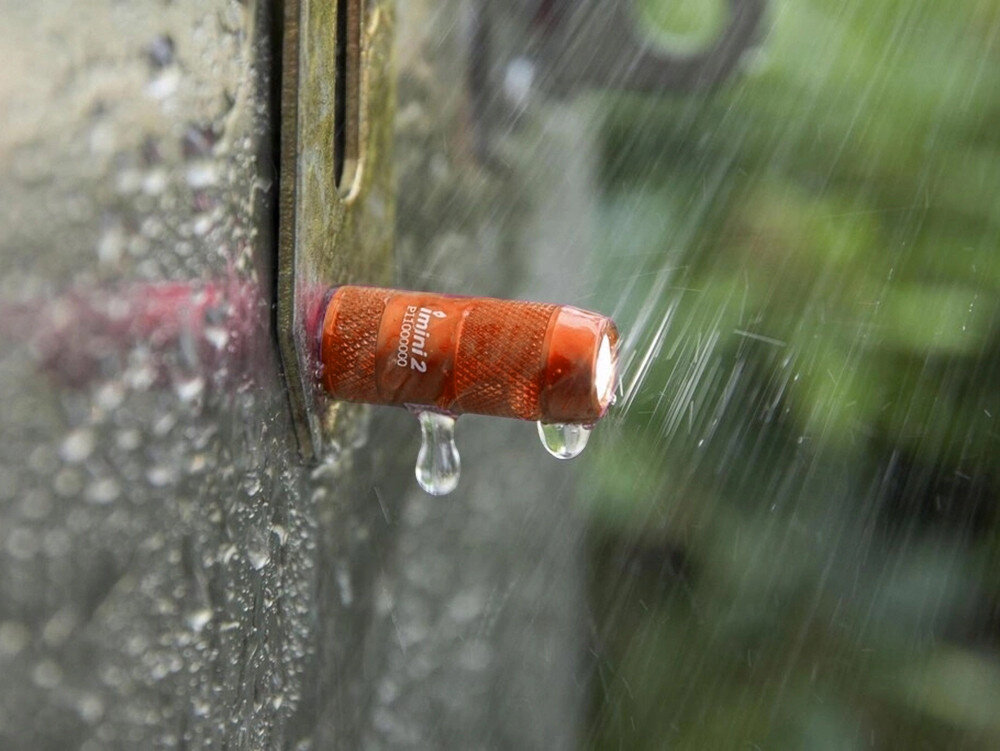 Latarka OLIGHT iMini 2 OL004417 Pomarańczowy, światło, brelok, ergonomia, wygoda, Mini latarka Olight noszona przy plecaku, outdoor, przypięta do taśmy transportowej.