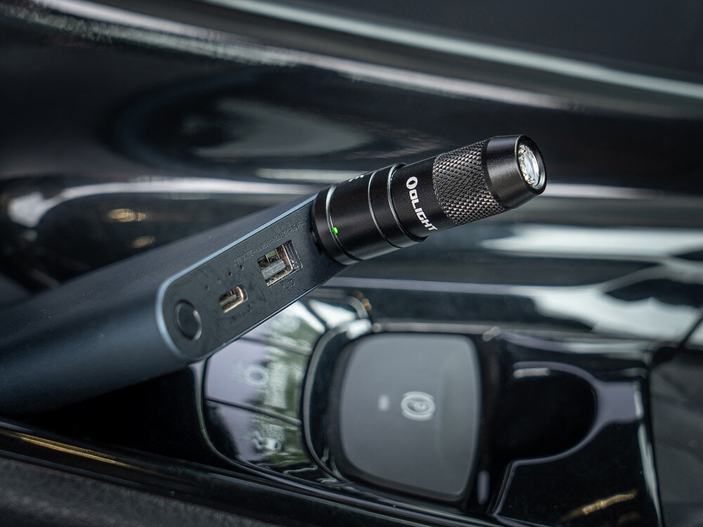 Latarka OLIGHT iMini 2 OL004417 Pomarańczowy, akumulator, długi czas, wydajne światło, Latarka Olight podłączona do powerbanku w aucie, dioda wskazuje ładowanie, zbliżenie.