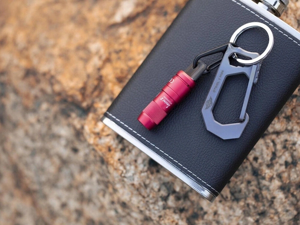 Latarka OLIGHT iMini 2 OL692265 Czerwony, światło, brelok, ergonomia, wygoda, Mini latarka Olight noszona przy plecaku, outdoor, przypięta do taśmy transportowej.