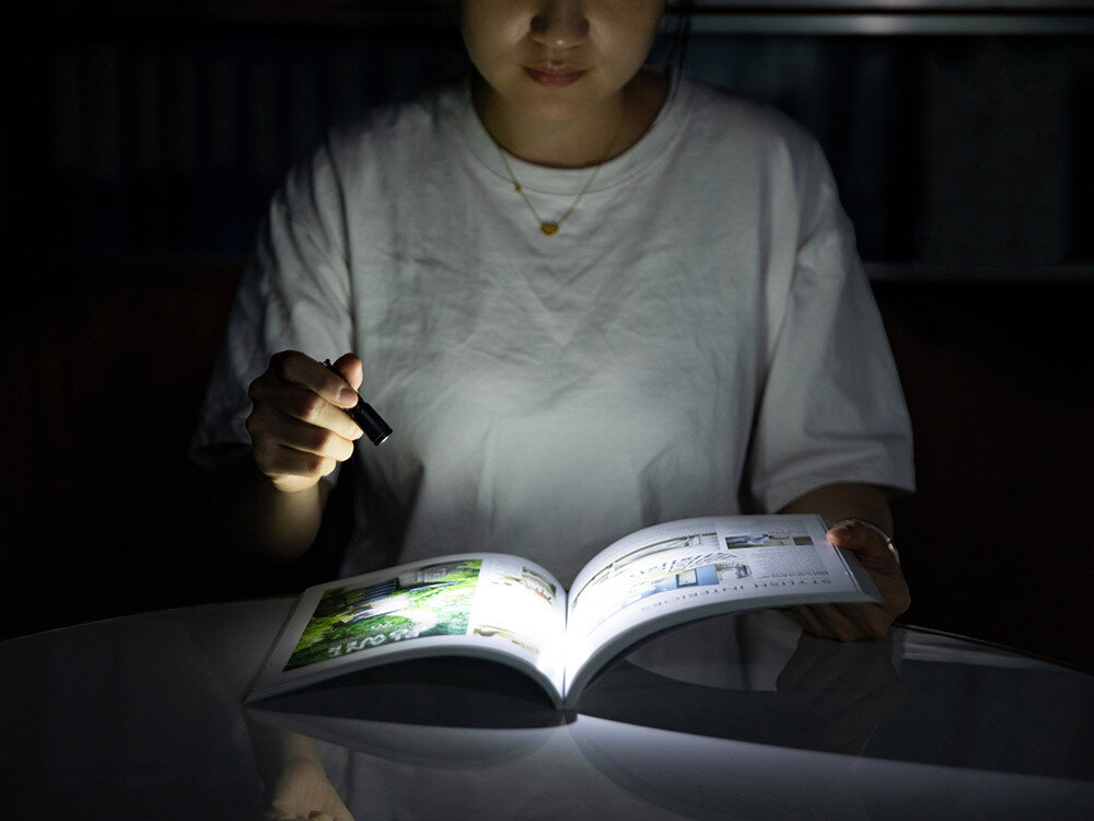 Latarka OLIGHT I3E EOS OL692821 Letnie Palmy Zielony, równomierny, szeroki, strumień, TIR, Kobieta czyta książkę przy świetle miniaturowej latarki Olight I3E EOS, blask na stronach.