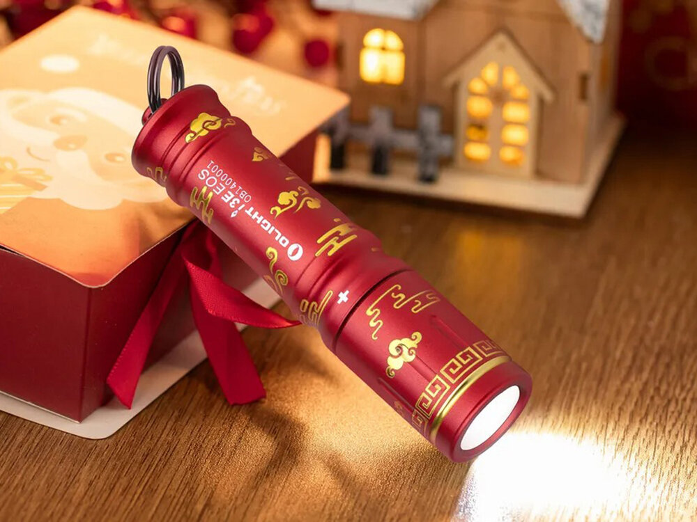 Latarka OLIGHT I3E EOS OL691503 Czerwony, miniaturowa, jasność, 90 lumenów, codzienne,  Limitowana czerwona latarka Olight I3E EOS z motywem chińskim, oświetla blat, dekoracje w tle.