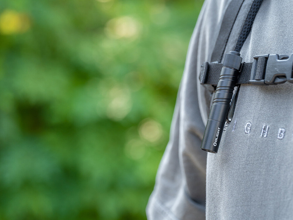 Latarka OLIGHT I3T 2 EOS OL002901 Czarny, stabilna temperatura, ciągłe świecenie, energooszczędny tryb, długa wydajność, Latarka Olight I3T 2 EOS przypięta klipsem do szelek plecaka, gotowa do szybkiego użycia