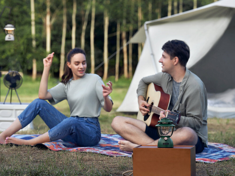 Latarka OLIGHT OL126177 Latarnia biwakowa, 11200mAh, 180h, USB-C, MCC3, Olantern Classic na kocu podczas grania na gitarze